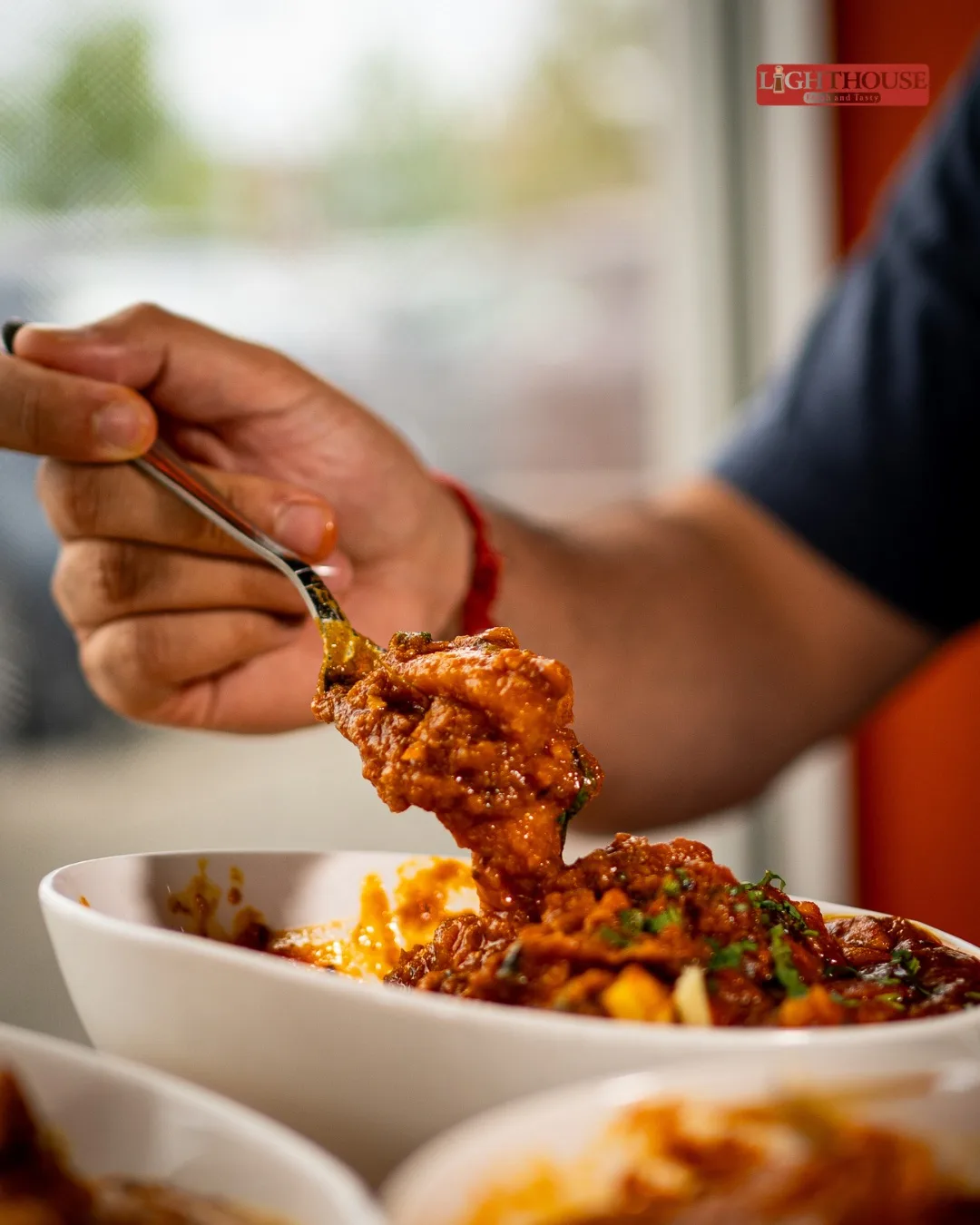A guest enjoying freshly prepared Indian food at Lighthouse Indian Kitchen